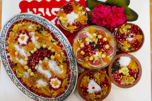 传统的甜点果冻，阿舒拉，诺亚的布丁，放在木制圆板上的碗里。从上<strong>往下</strong>看，用斜体字体用英文书写：阿舒拉日，土耳其文.