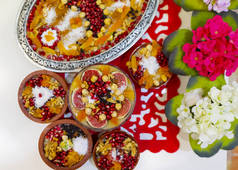 传统的甜点果冻，阿舒拉，诺亚的布丁，放在木制圆板上的碗里。从上往下看，用斜体字体用英文书写：阿舒拉日，土耳其文.