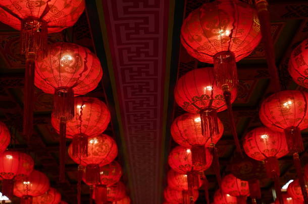 许多灯亮着红色<strong>的</strong>中国灯笼，上面有一些<strong>汉字</strong>