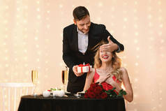 一个浪漫的男人在餐馆用礼物给他的女朋友一个惊喜