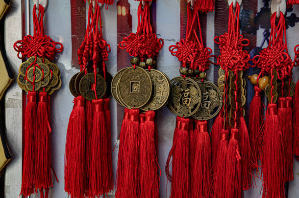 东亚是好运的象征。中国传统的纪念品，由古铜币和红色交织纱线装饰制成，有长长的流苏。农历新年东洋礼品零售展览.