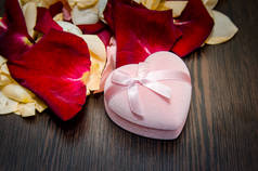 花瓣玫瑰与礼品盒在桌子上。情人节理念背景
