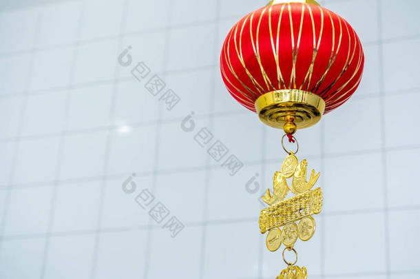 红色的中式吊<strong>灯</strong>挂在白色房间的背景上，带有复制空间，是中国新年的装<strong>饰品</strong>。1.<strong>灯</strong>笼上的文字是用来问安的.