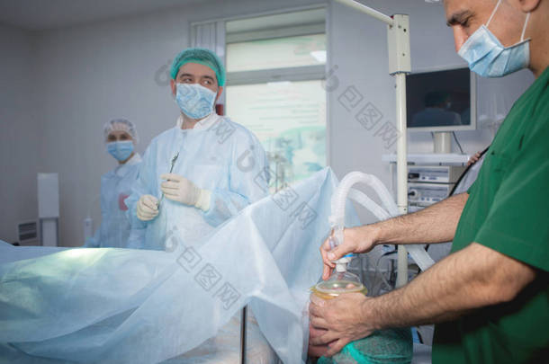 麻醉师在手术前给病人戴上<strong>吸入</strong>麻醉面罩.