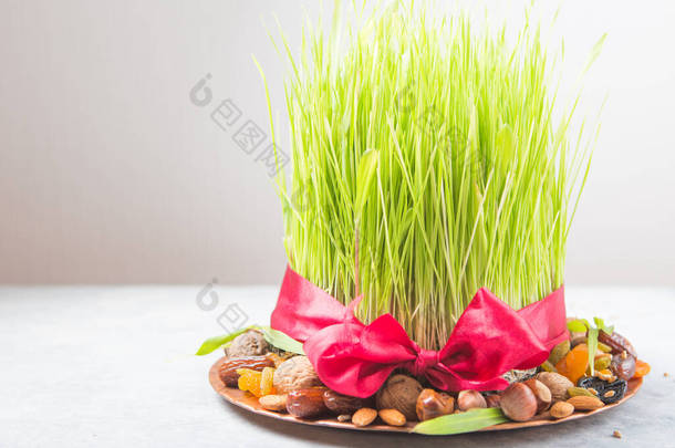 诺鲁孜<strong>节</strong>快乐。庆祝各种干果，<strong>坚果</strong>，种子，绿色青草小麦的颜色背景，复制空间顶部视图
