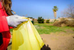 志愿者们在大自然中回收的装满塑料瓶的垃圾袋.