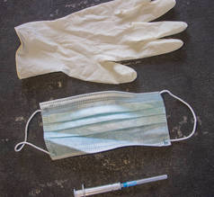 考罗纳威和流感控制。医疗面罩，带针头的注射器和黑色背景的橡胶手套. 