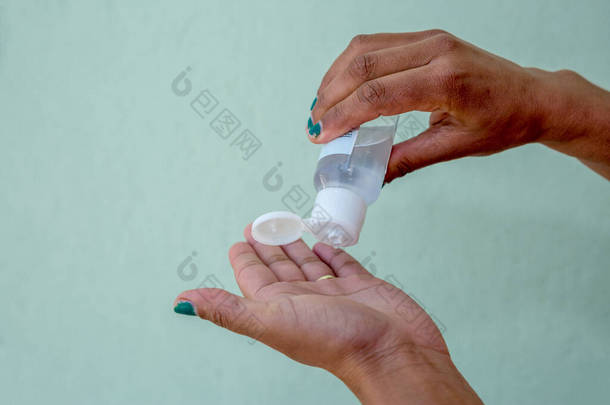 妇女在手上使用手提式抗菌<strong>手部清洁剂</strong>的近景