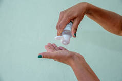 妇女在手上使用手提式抗菌手部清洁剂的近景