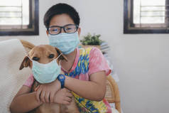 戴着医疗面具的男孩给他的狗戴上医疗面具。照顾所爱的人基本卫生规则.