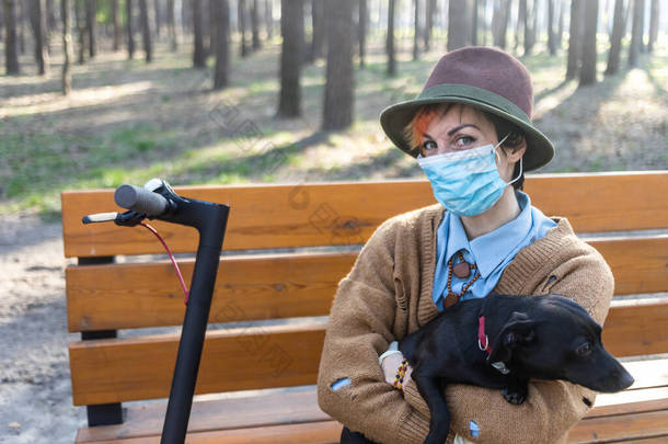 一个戴着面具和手套的<strong>时</strong>髦女人，让她<strong>远离</strong>了考拉威斯。在城市和公园里使用电动车是为了安全。和她的狗玩的开心.