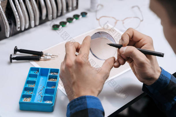 眼镜的衣服放在桌子上,有许多庙宇,不同的颜色和形状.眼镜的专业制造和修理.光学测量和制作眼镜