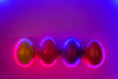 一组色彩艳丽的彩蛋在双色时髦的霓虹灯背景与梯度背光。复活节的概念。平铺风格.