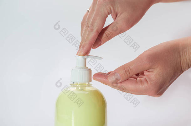 手把喷雾器放在装有液体肥皂的黄色瓶子上。24.横向方向。高质量的照片