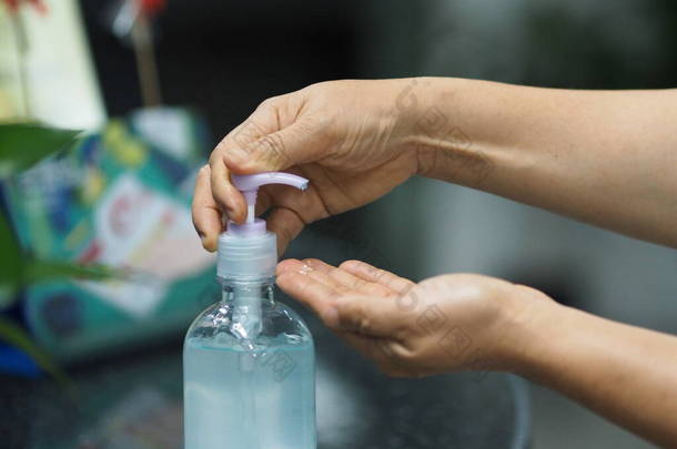 凝胶滴在手上，女人用手指捏着凝胶，70%的酒精和明胶混合在一起，以防止细菌感染，保护膜，<strong>手部清洁剂</strong>