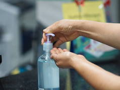 凝胶滴在手上，女人用手指捏着凝胶，70%的酒精和明胶混合在一起，以防止细菌感染，保护膜，手部清洁剂