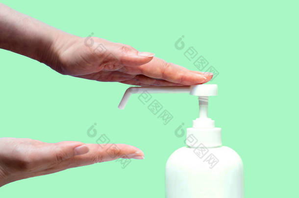 一个女人用塑料喷雾器喷出的防腐剂喷她的手。手与瓶子特写在黄绿色的背景。流行病期间的卫生治疗.