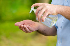 人的手使用洗涤手酒精凝胶或清洁剂瓶子分配器，对抗考薇19号。防腐、卫生和健康概念.