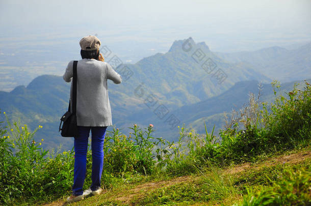 女子站在高山上与天空相对照的背景图.