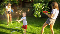 快乐的孩子们在花园里玩花园的水管