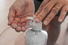 在家里，使用清洁剂的妇女用清洁剂凝胶液擦拭手，清洁个人卫生。更干净的瓶子.