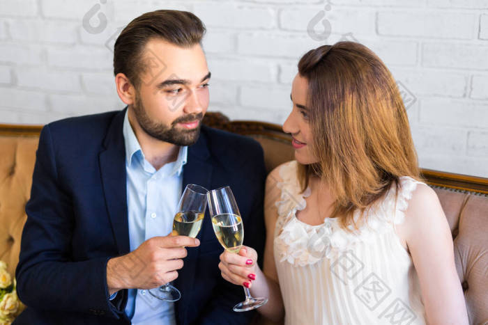 约会的概念年轻漂亮的夫妇在家里喝香槟图片-包图网企业站