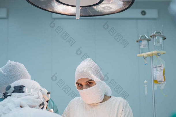 行动小组。女外科医生在手术过程中看着摄像机。无菌手术室的条件。对病人内<strong>脏器</strong>官的外科干预