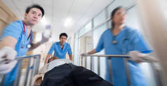 医生奔向手术室的前景，医生推着病人紧急服务医院的背景