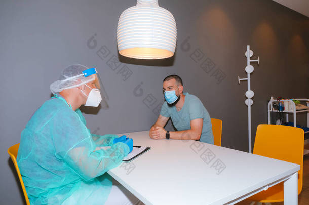 在现代诊所看病的医护人员戴着面罩和面罩