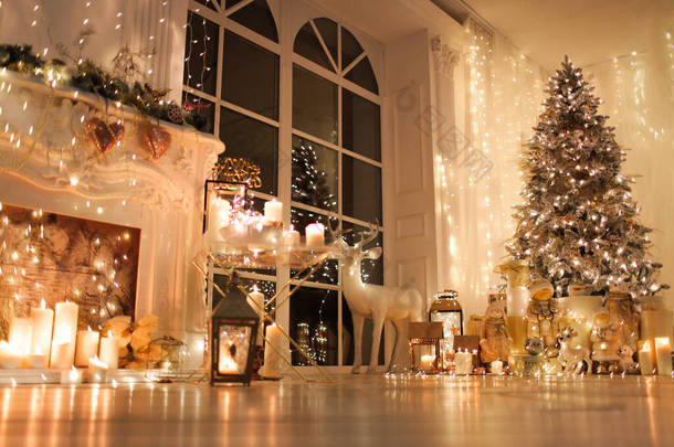 圣诞室内设计温馨舒适的夜晚，圣诞树上点缀着彩灯，礼物，玩具，鹿，蜡烛，灯笼，室内壁炉。