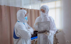 穿着安全制服和医疗面罩的专业医生小组在医院为治疗和照顾病人提供保护 .