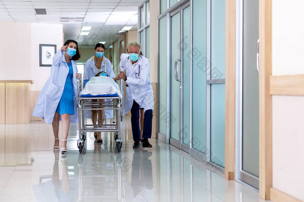 队医推动女病人住院的担架轮床走廊。保健概念