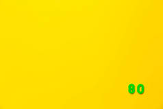 A green plastic toy number 80 is located in the lower right corner on a yellow background.