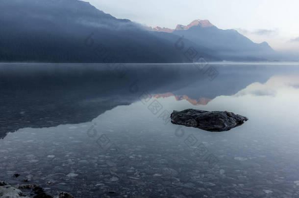 日出时分，在英加丁山谷的Silvaplana湖中映出的群山，雾气笼罩着水面
