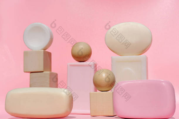 粉红背景的时髦肥皂套装设计。天然肥皂条，木制立方体和球。清洁和卫生。自我照顾的概念。温泉治疗.