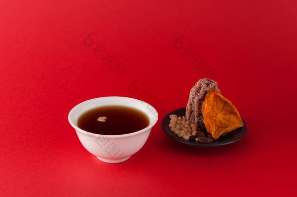 韩式果子酱或茶-红色背景，有梯度。它是用干柿子和松果制成的.