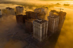在晨雾中，从无人驾驶飞机俯瞰高层大楼，部分房屋正在建造中.