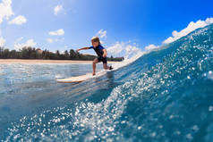 快乐的冲浪男孩-年轻的冲浪运动员学习骑在冲浪板上,在海浪中玩乐.积极的家庭生活方式，孩子们户外水上运动课，在冲浪营游泳活动。带孩子的暑假