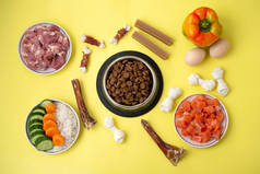 将宠物狗的食物放入装有天然配料和处理的碗中晾干.生肉，鱼，蔬菜，鸡蛋。宠物、平铺正确、均衡、健康营养菜单的概念