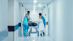 急诊部：医生、护士和医护人员将重伤员推入手术室。明快的现代化医院及医护人员拯救生命.