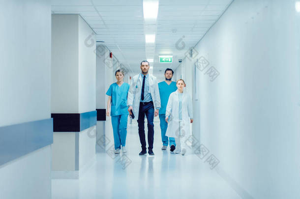 医生、<strong>外科</strong>医生和护士队伍走过繁忙的医院<strong>走廊</strong>，他们谈论病人、即将到来的手术和拯救生命。配备专业人员的清洁现代化医院.