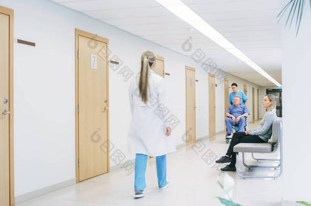 在医院的走廊里，忙碌的专业人员<strong>走过</strong>，护士推着轮椅上的老人，病人在等医生。全新医院，配备专业医护人员.