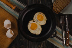 煎蛋。把煎蛋放在铁锅里的近景.背景暗的顶视图.