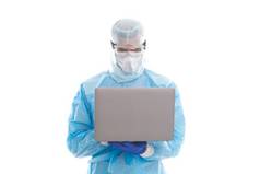 在禽流感大流行期间，男医生流行病学家戴着口罩和安全防护服，在计算机上工作，在线帮助.