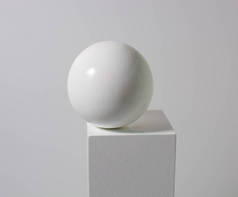 白色立方体上的白色球，白色背景上的白色球。美感简约的概念，汲取教训。复制空间.