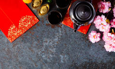 中国的新年装饰品，汤匙或红包，橙色和金色的镶嵌在深色的石头背景上。文章中的汉字FU指的是好运、财富、资金流动.