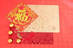 中国新年装饰用红色和金色饰品，红色桌上用红色和金色桌布点缀两支彩灯