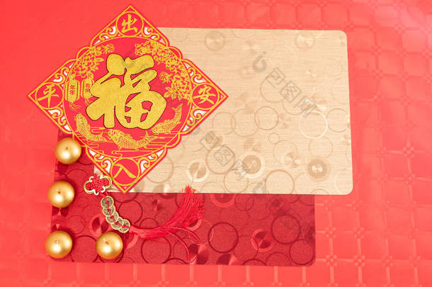 中国新年<strong>装饰</strong>用红色和金色饰品，红色桌上用红色和金色桌布点缀两支<strong>彩灯</strong>