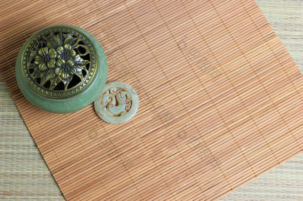中国的香炉,传统的硫铁矿饰品和竹席背景.安静的生活。复制空间