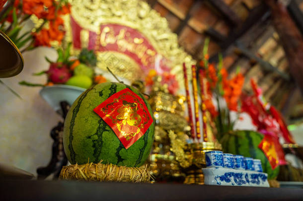 在越南节日期间，在祖先的祭坛上关上了一个西瓜。照片中的金色文字意味着和平。有选择的重点.